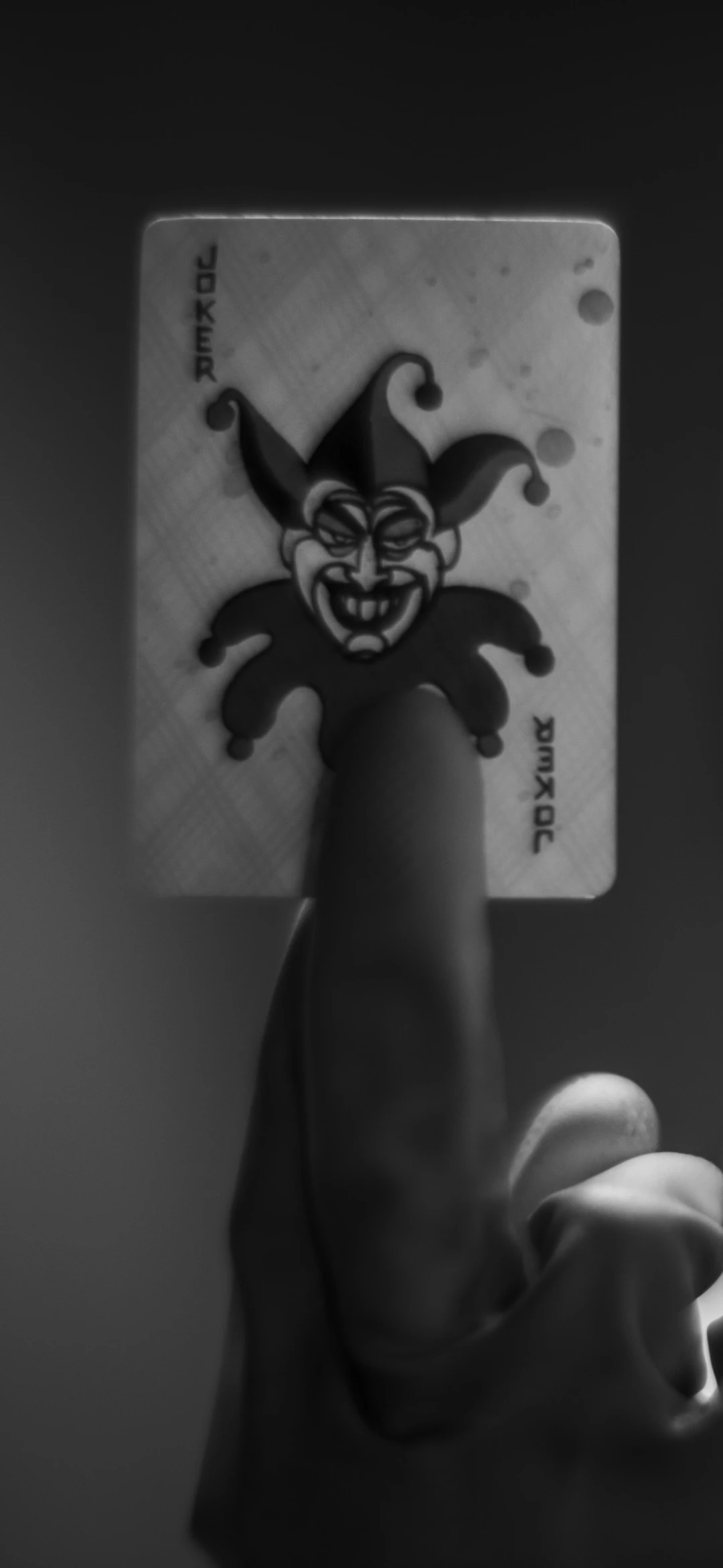 Monochrome Joker Card Balanced on Finger