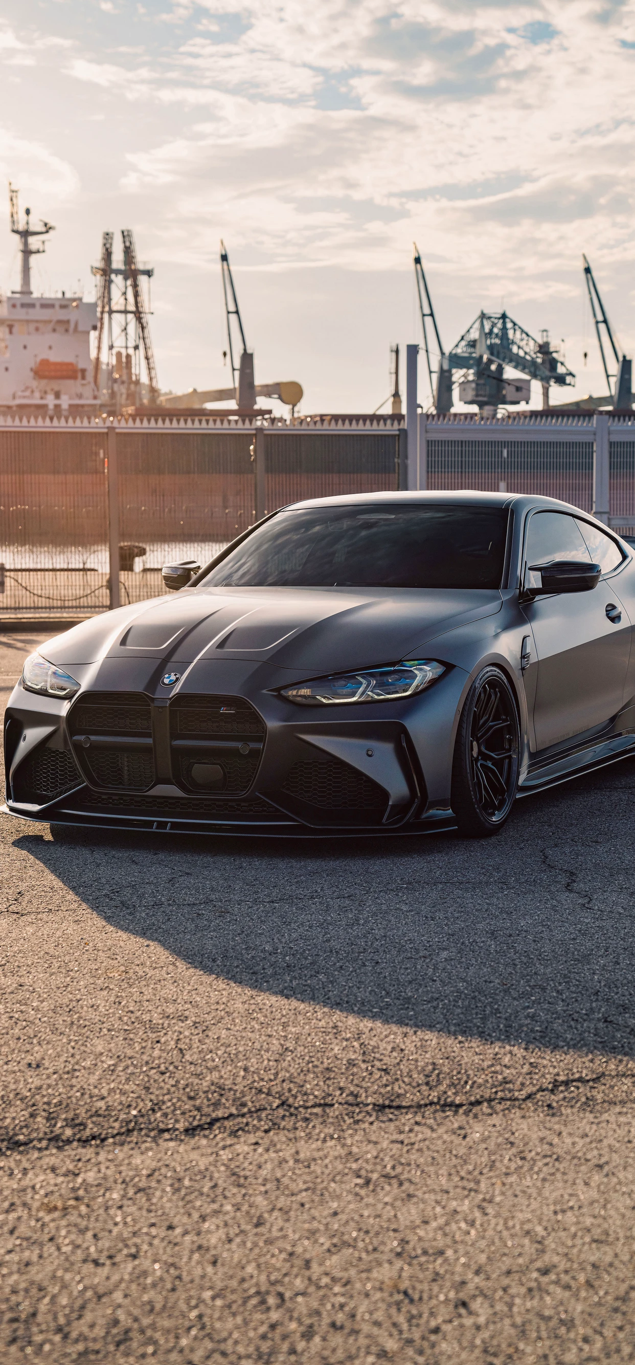 Sleek Matte Gray Car Against Industrial Backdrop